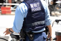 A police officer standing in the city. Taken in July 2022 in Taito-ku, Tokyo.