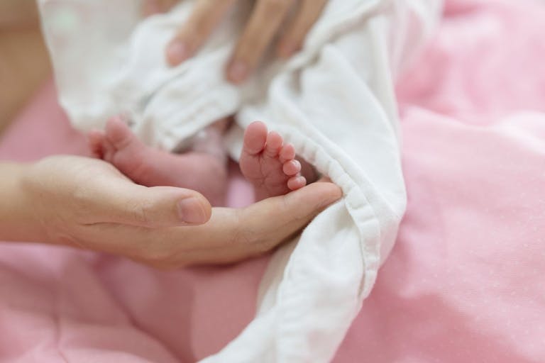 A Heartwarming Moment of Love and Tenderness as Mothers Touch Newborn Baby's Feet Are Tenderly Caressed - stock photo