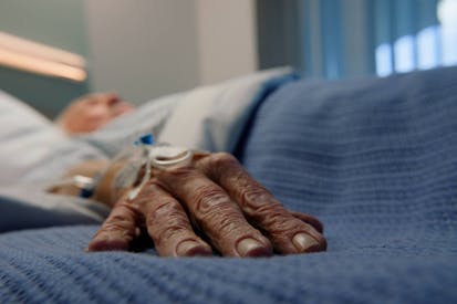 Elderly man, hands and bed in hospital for with iv drip for stroke, healthcare and medicine. Senior patient, sleeping and gurney in clinic for cancer, health and life extension drugs with metmorfin