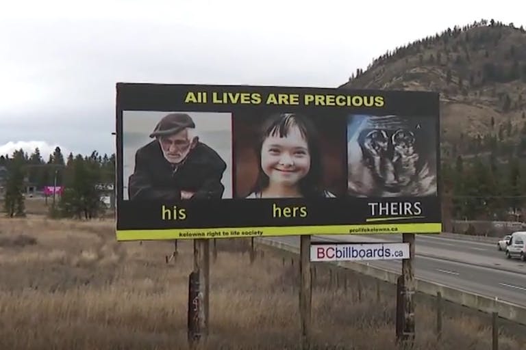 Screenshot: Global News (Canada) A billboard showing a picture of an old man, a girl with Down syndrome, and an ultrasound of twins in the womb. It states, 'All lives are precious.'