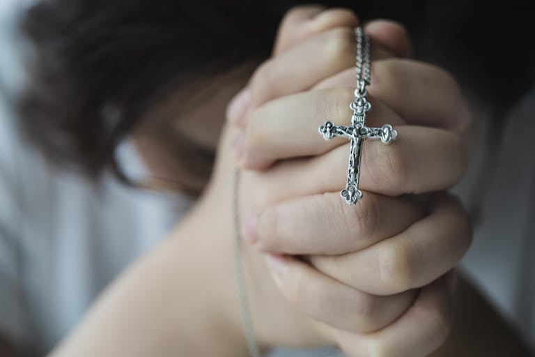 Photo: Kilito Chan/Getty Images female hand holding rosary beads