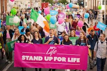 Photo by Niall Carson/PA Images via Getty Images Photo shows pro-life activists marching in the Ireland March for Life in 2022 with a pink banner stating: "Stand up for life."