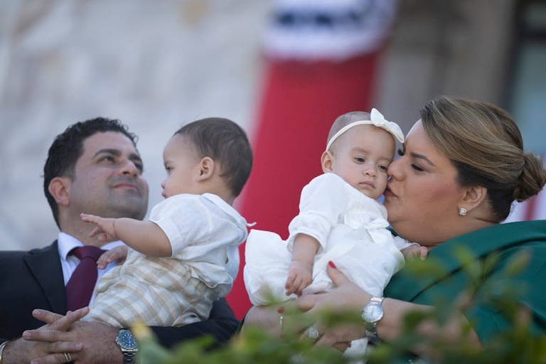Photo by RICARDO ARDUENGO/AFP via Getty Images Governor-elect Jenniffer Gonzalez and her husband, Jose Yovin Vargas hold their babies during her swearing in ceremony at the Capitol building in San Juan, Puerto Rico on January 2, 2025. (Photo by Ricardo ARDUENGO / AFP) (Photo by RICARDO ARDUENGO/AFP via Getty Images)