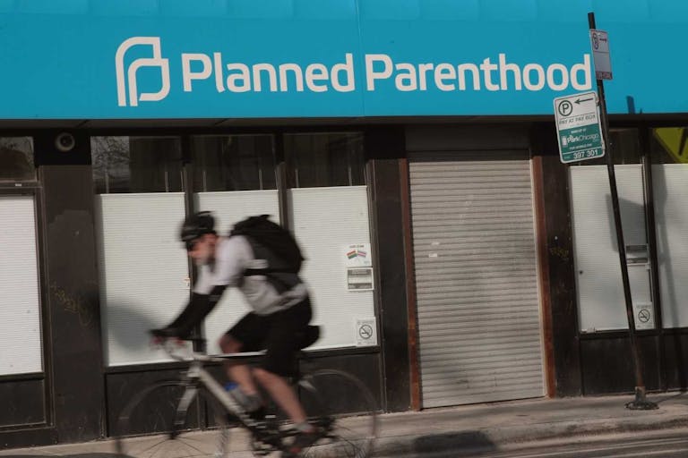 Photo by Scott Olson/Getty Images CHICAGO, IL - MAY 18: A cyclist rides past a Planned Parenthood clinic on May 18, 2018 in Chicago, Illinois. The Trump administration is expected to announce a plan for massive funding cuts to Planned Parenthood and other taxpayer-backed abortion providers by reinstating a Reagan-era rule that prohibits federal funding from going to clinics that discuss abortion with women or that share space with abortion providers. (Photo by Scott Olson/Getty Images)