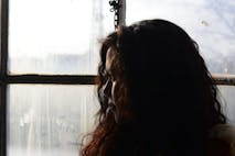 A woman looks out a window.