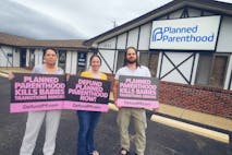 Image shows three pro-life activists holding Defund Planned Parenthood signs outside of the now-closed Rolla Planned Parenthood in 2025.