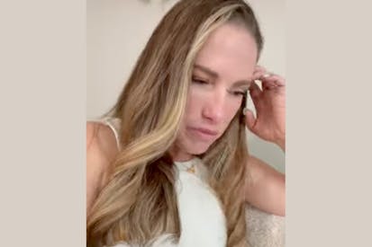 The image is a screenshot of a video of Jess Djukanovic. She is looking down with her hand by her head.