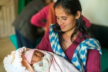Photo: Alex Treadway/Getty Images A mother holds her newborn baby in a hospital in Nepal