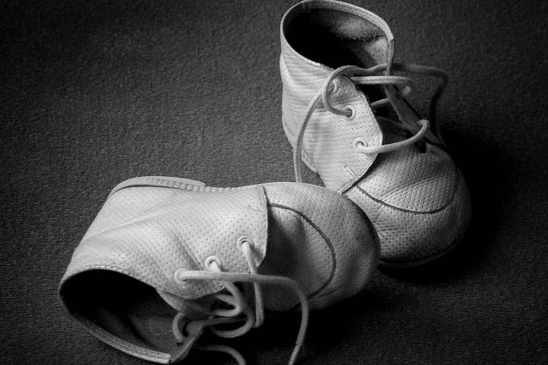 Photo: Anastazzo via Getty Images/iStockphoto Pair of old tiny baby shoes. Black and white with copyspace.