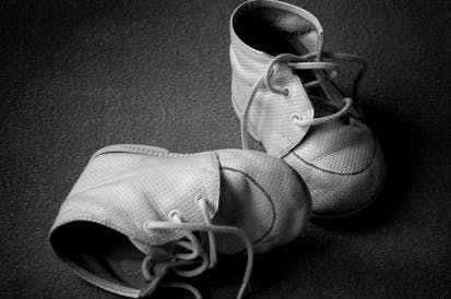 Pair of old tiny baby shoes. Black and white with copyspace.