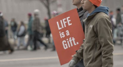 March for Life participants carry a sign saying "Life is a gift."