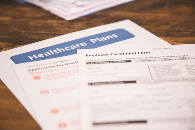 Photo: fstop123/Getty Images Open enrollment healthcare benefit forms. - stock photo