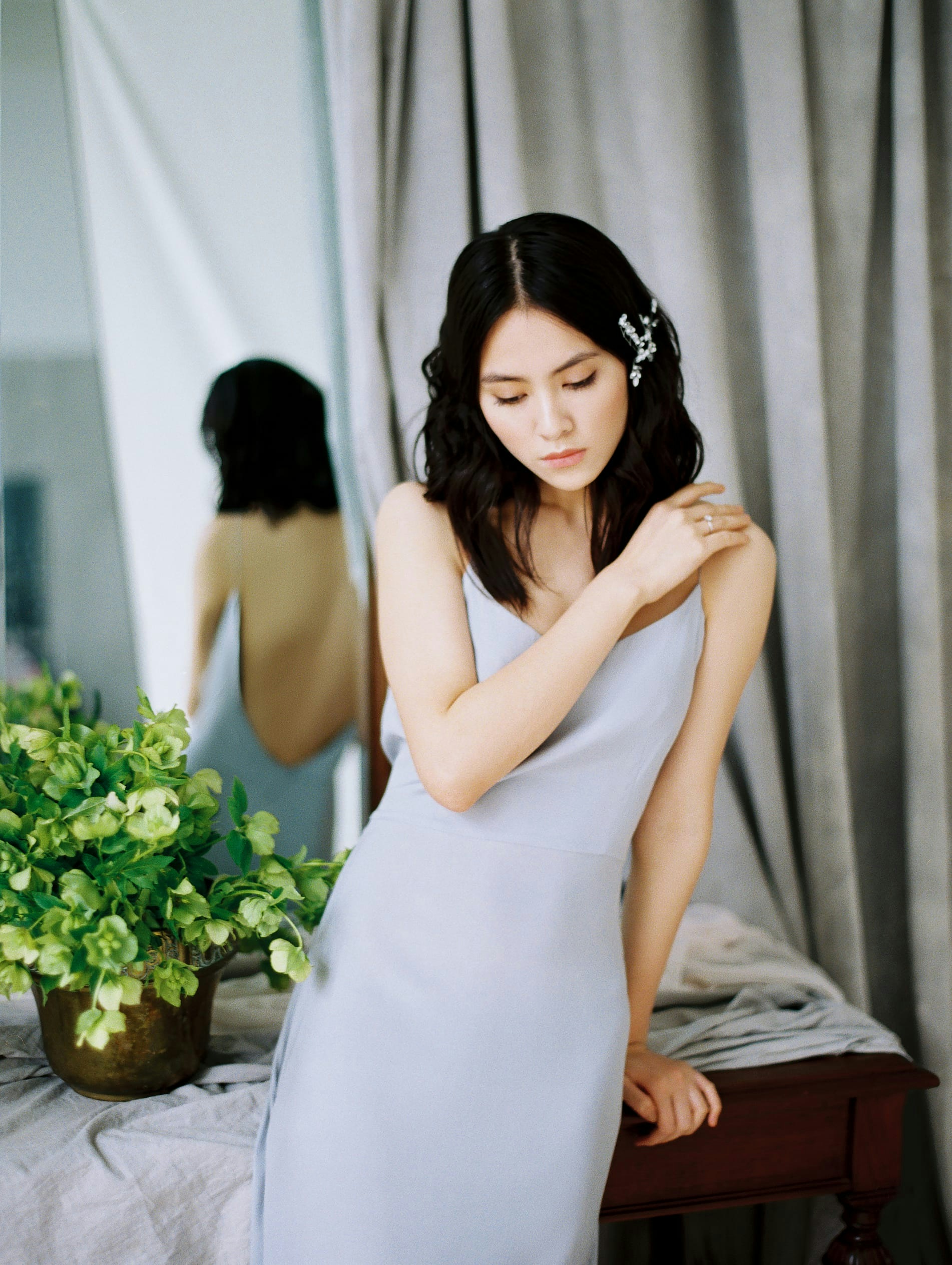 Woman in a dress leaning against a table