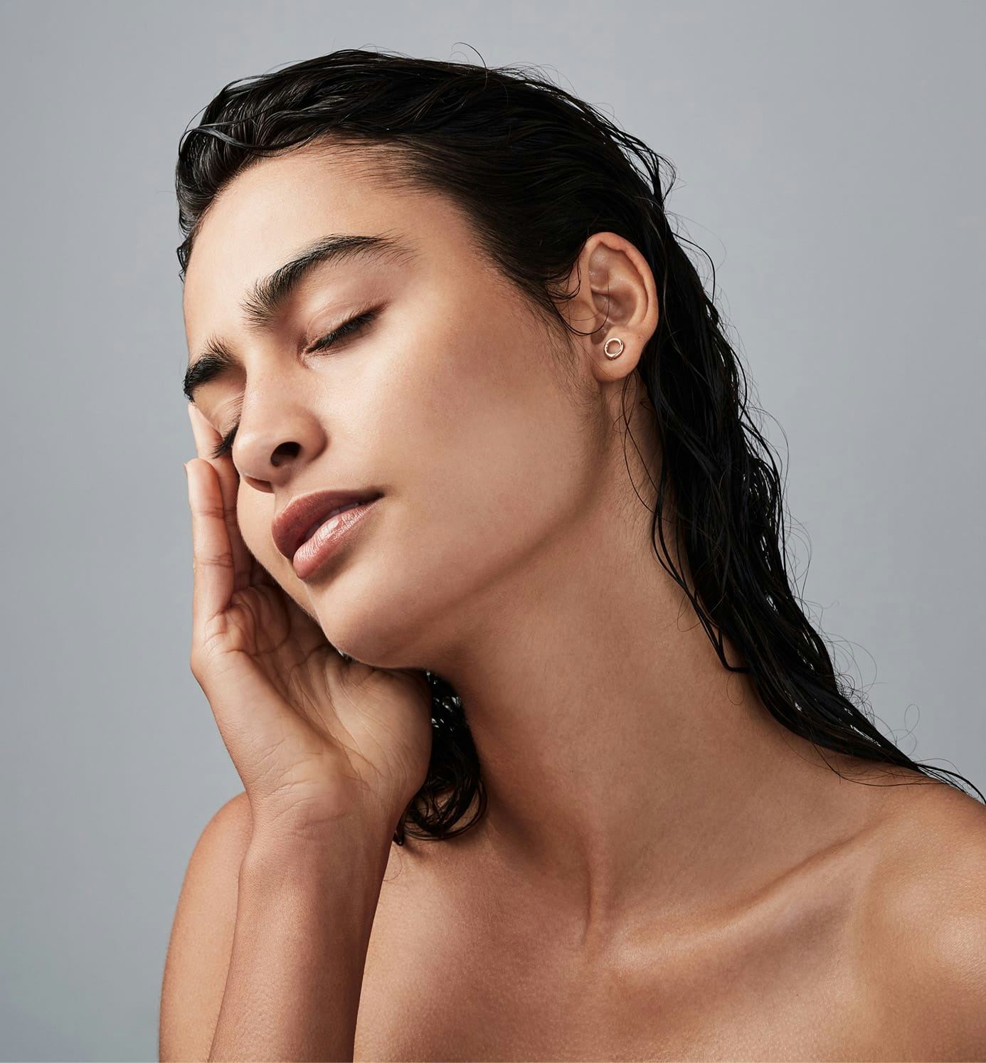 woman with wet hair resting face on her hand