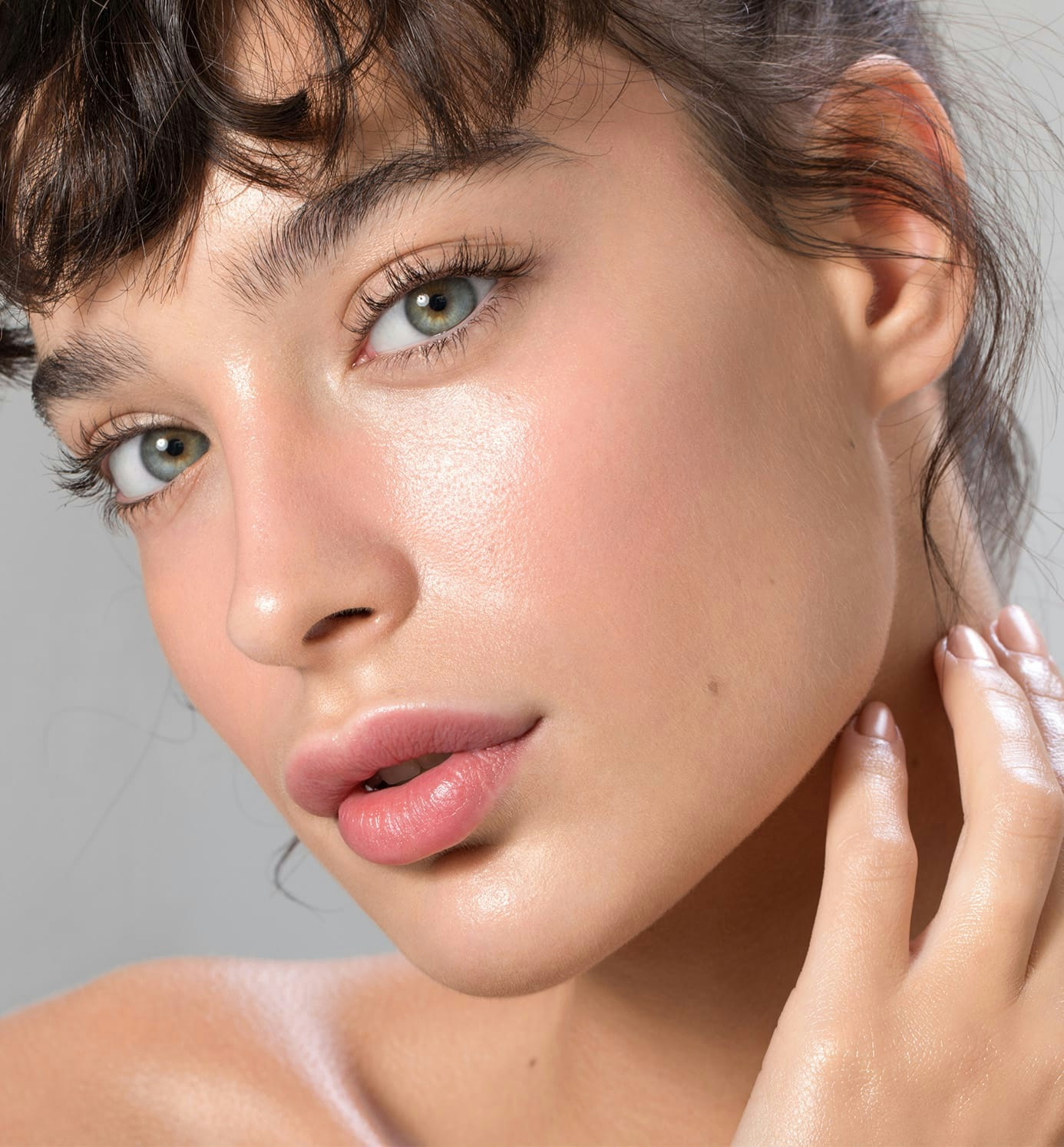woman with blue eyes looking forward with hand touching neck