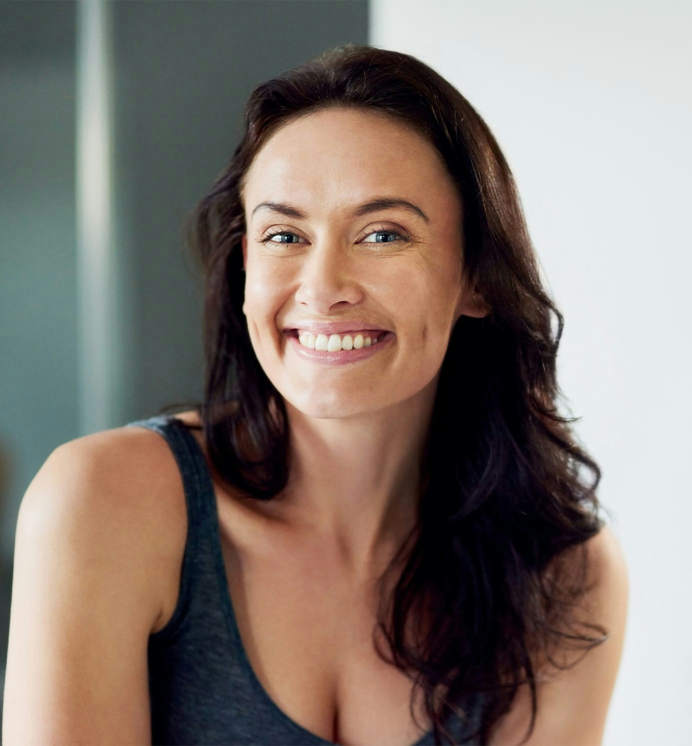 woman with brown wavy hair smiling forward