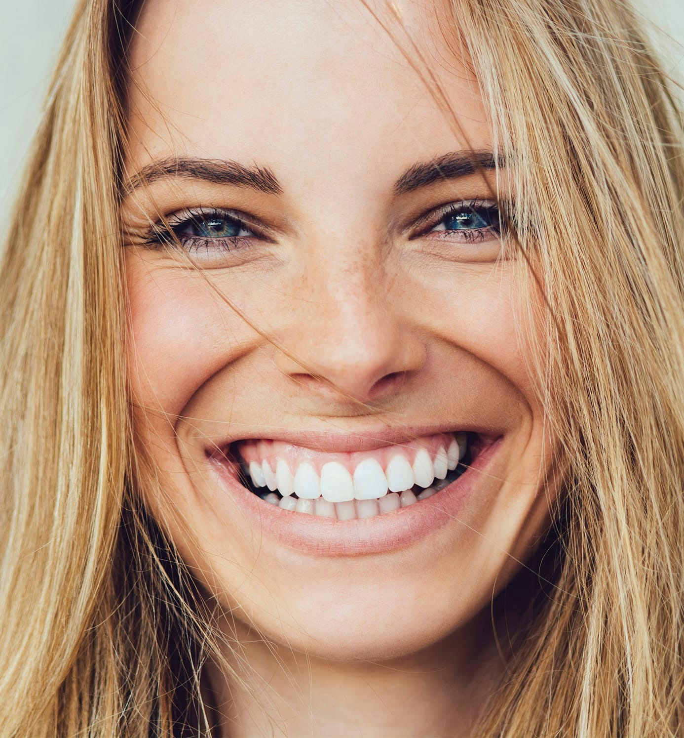 woman with blonde hair smiling and looking forward