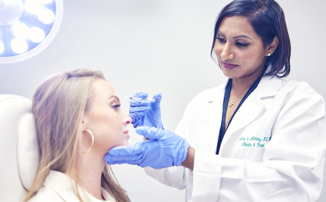 doctor holding syringe to patient's forehead