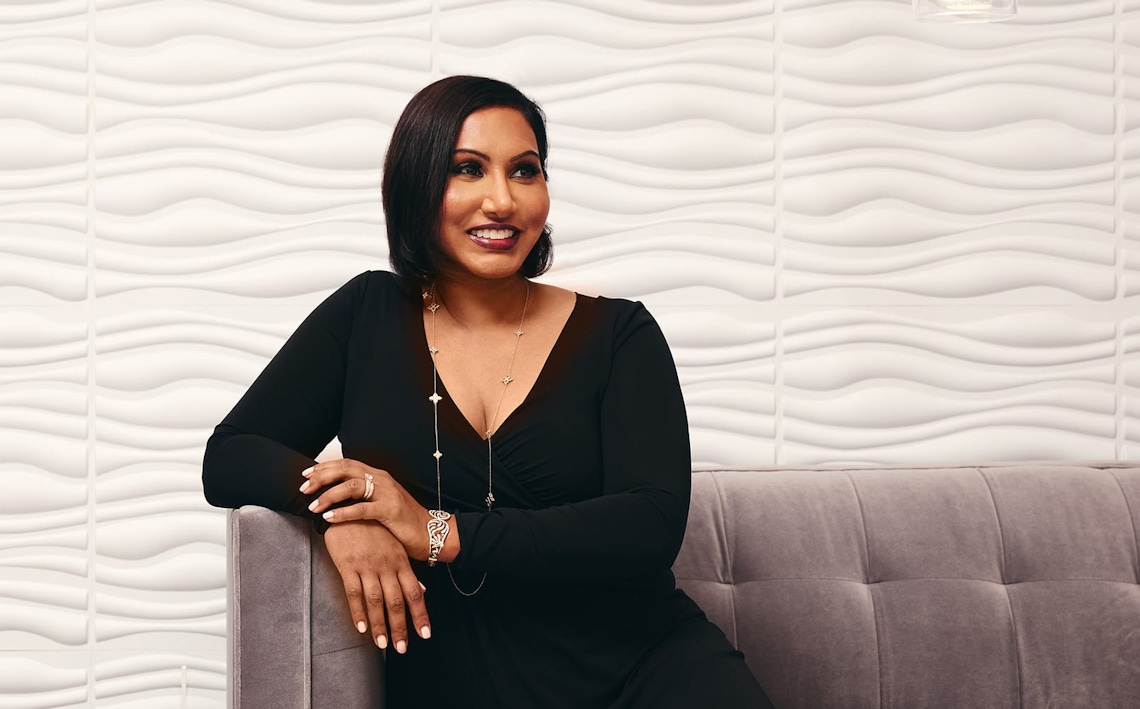 doctor in formal attire sitting on couch smiling