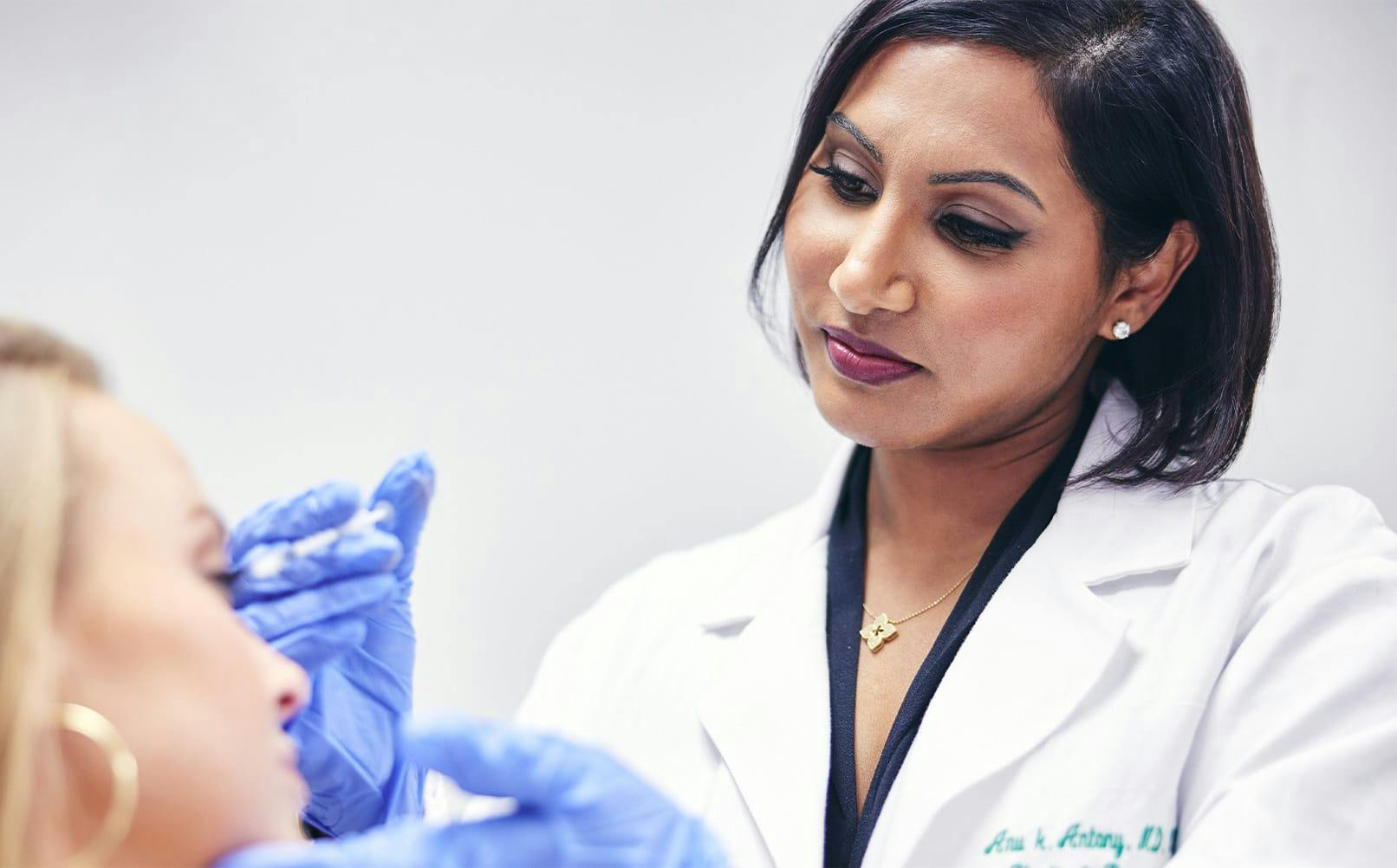 doctor holding syringe at patient's face