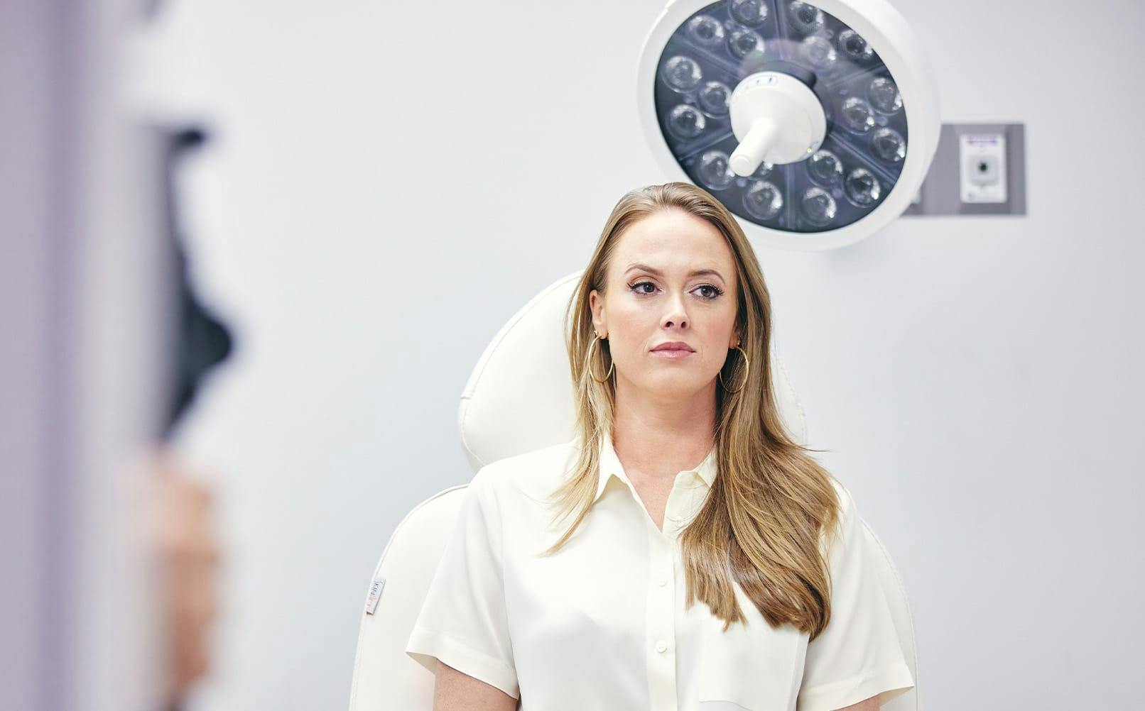patient sitting in seat with light above her head