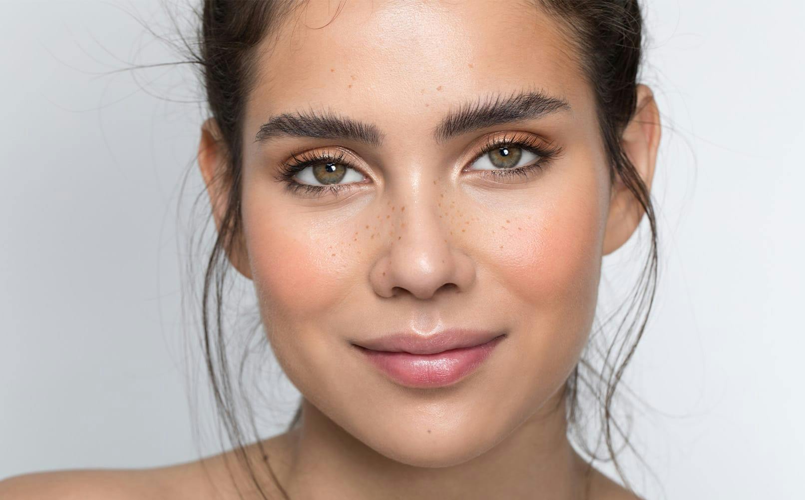 woman with hair in bun with green eyes