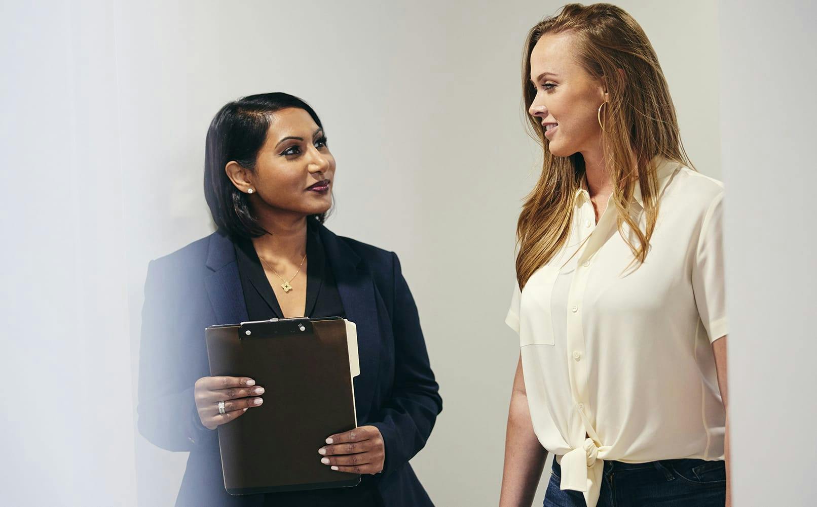 doctor speaking to patient while holding a clipboard