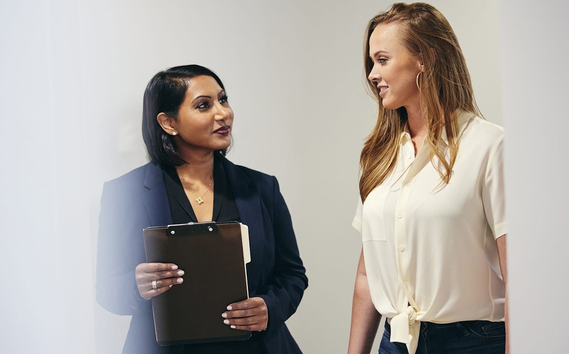 doctor speaking to patient while holding a clipboard