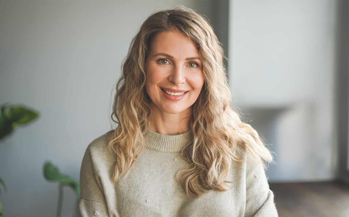 patient looking in handheld mirror while touching her hair
