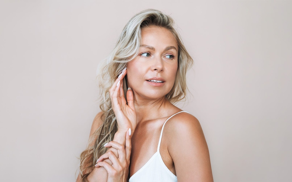docter about to touch patient's face while she looks into mirror