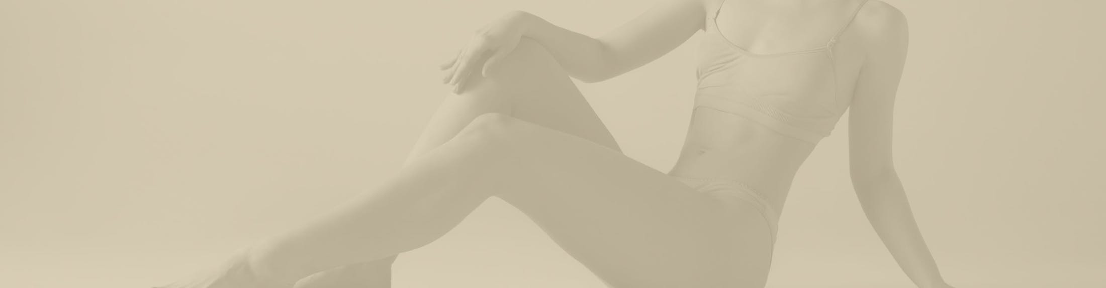 Woman sitting down, with a gold overlay over the image