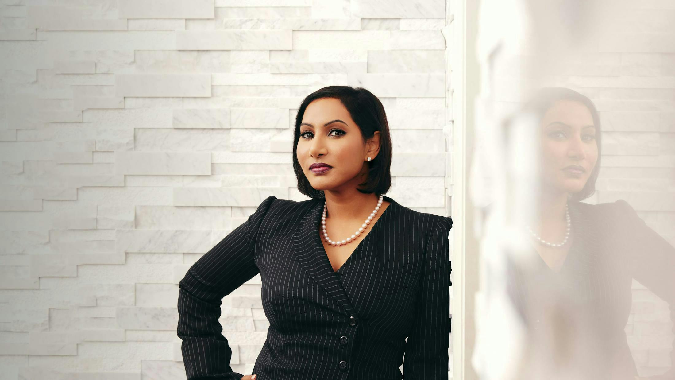 Dr. Anu Antony leaning against wall