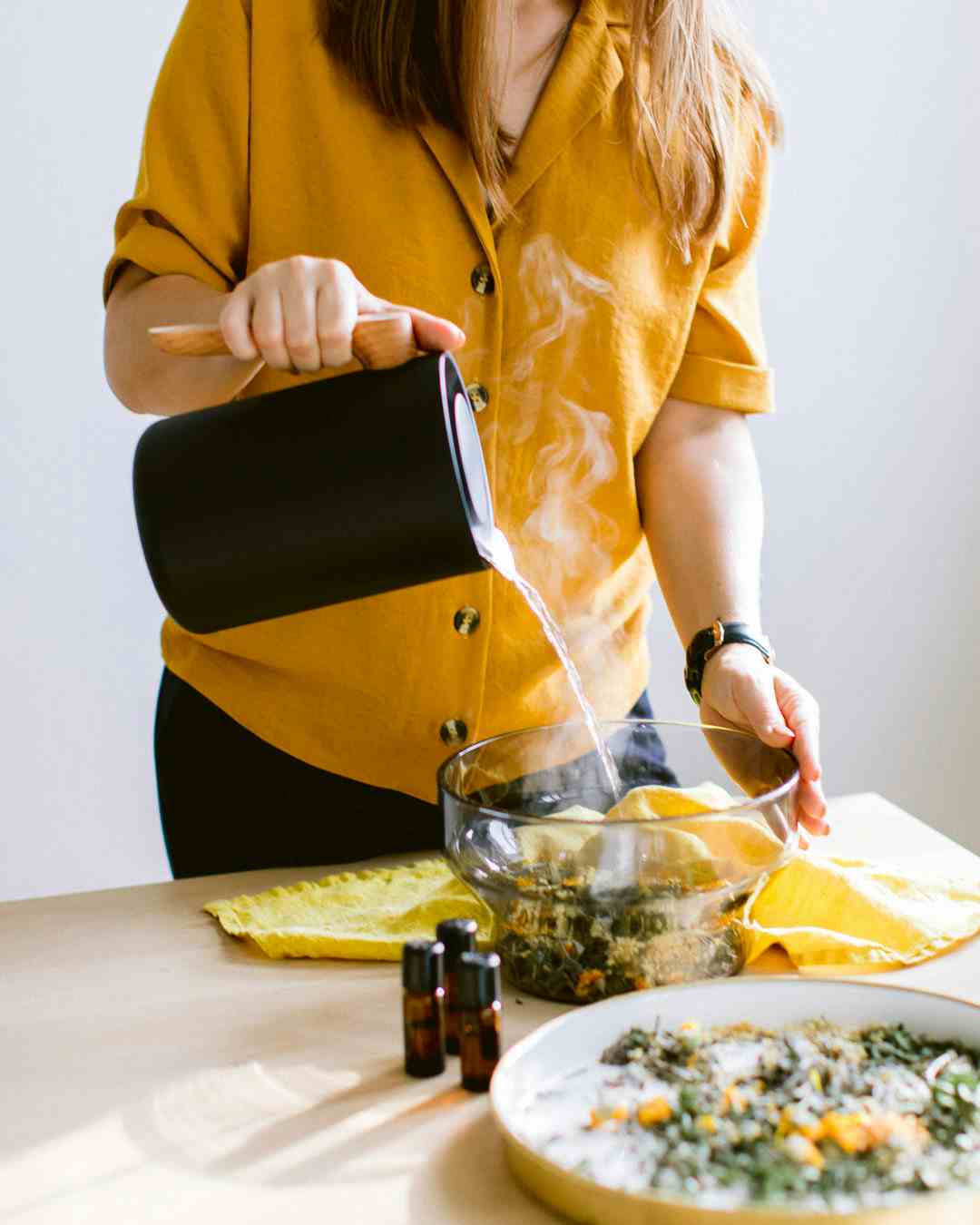 adding hot water into bowl with herb mix