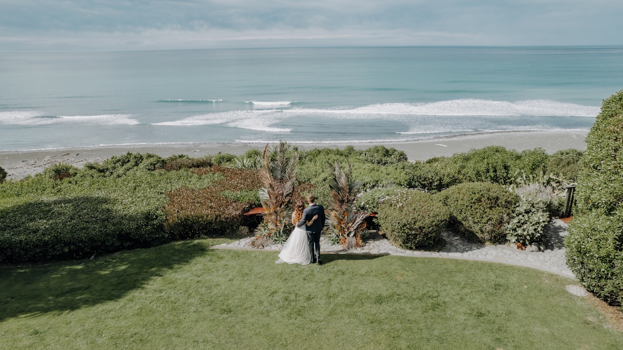 bride and groom looking over beach