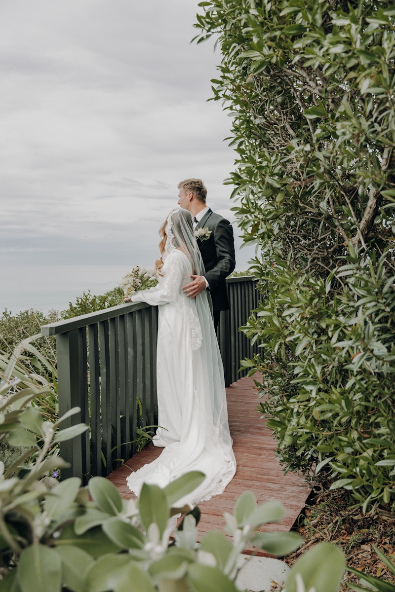 Bride and groom looking over ocean from property from deck