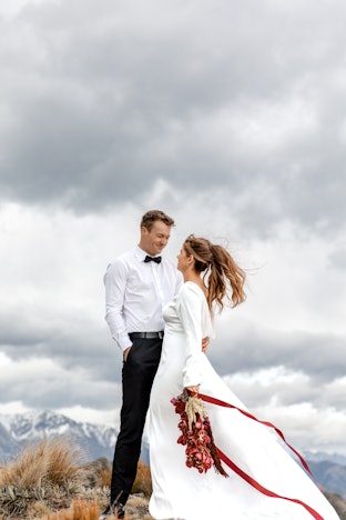Bride & Groom smiling at each other with mountains in background