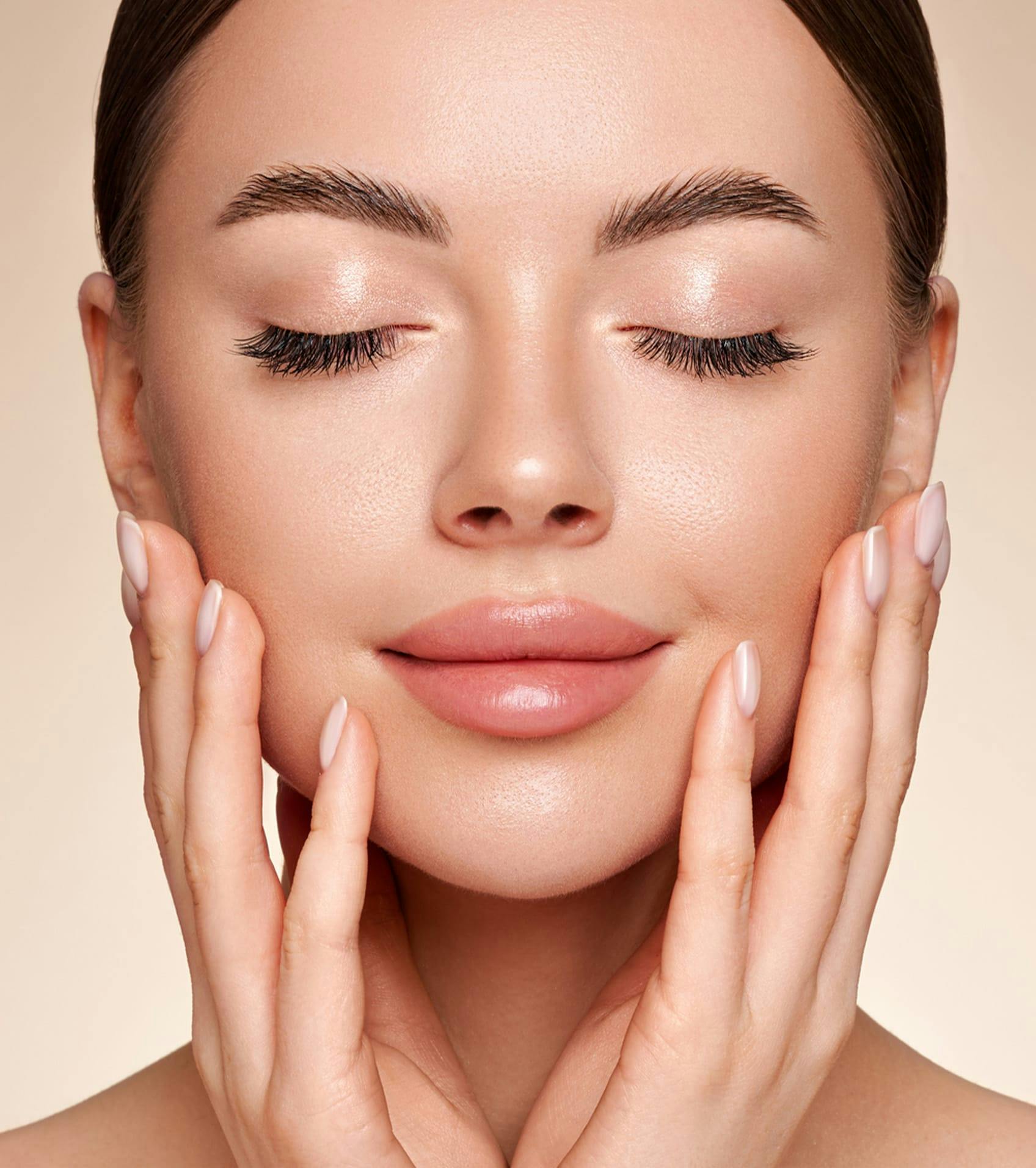 woman touching face with eyes closed