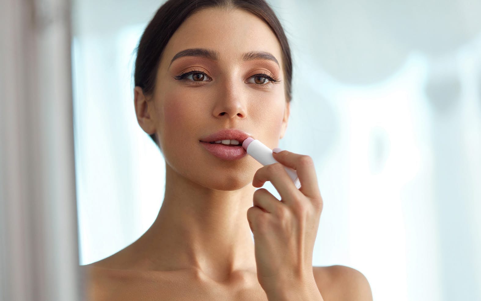 Woman applying lipstick
