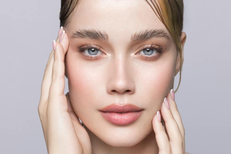 Close-up portrait of a woman with full, defined eyebrows.