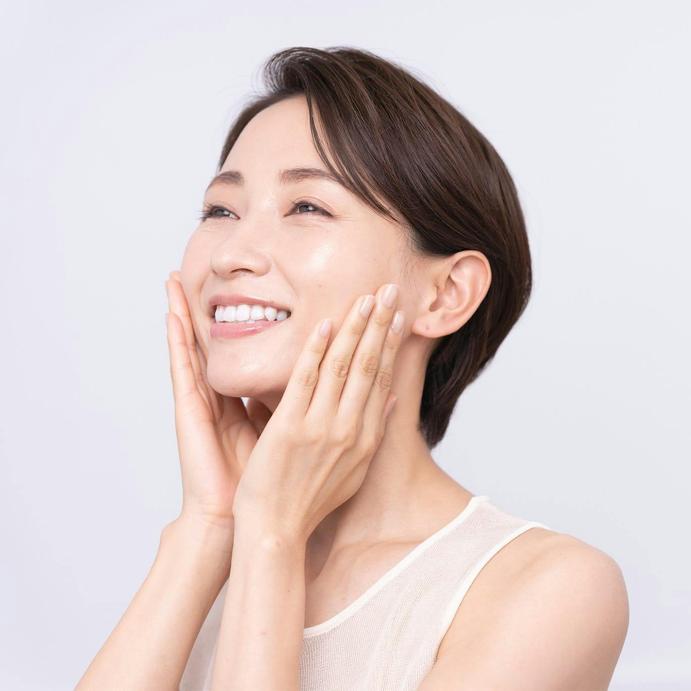 Smiling woman pressing hands to cheeks