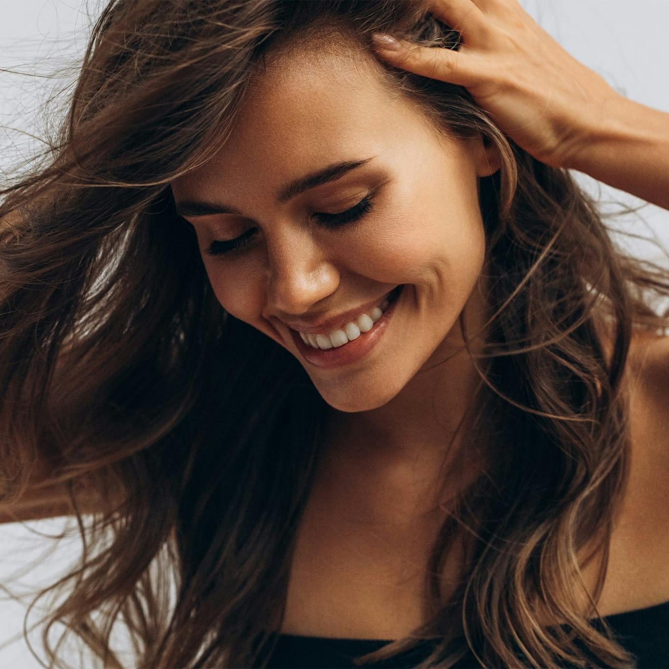 Woman laughing and holding hair