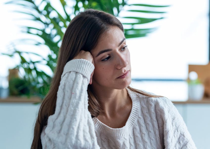 woman with worried expression resting head on fist