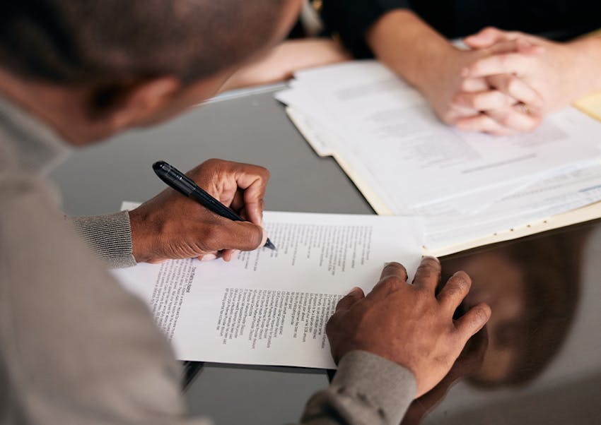 man signing document