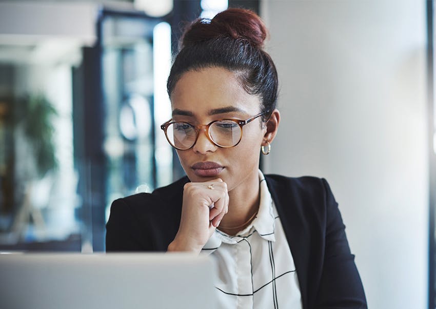 woman holding her chin staring at the laptop