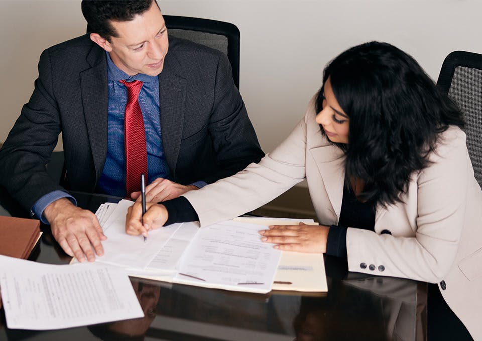 Michael G. Jacob and client signing a document