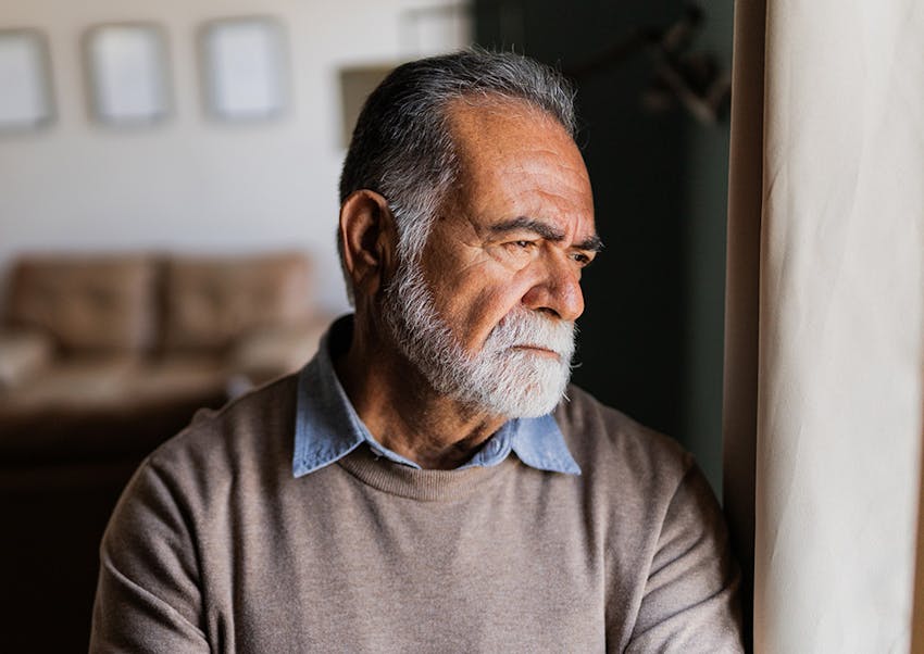 older man staring out window