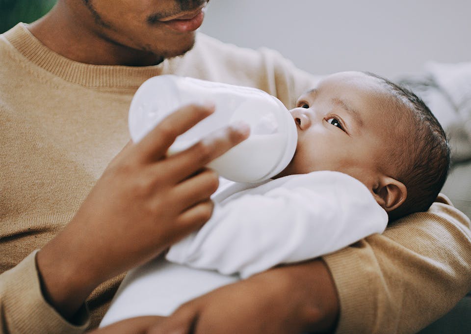 father feeing baby a bottle