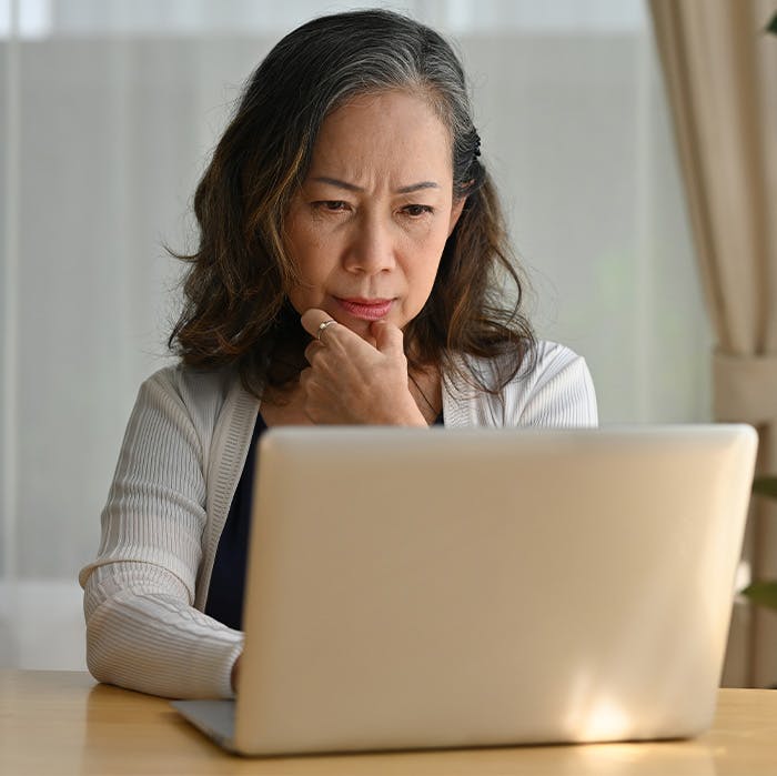 older woman looking studiously at her laptop