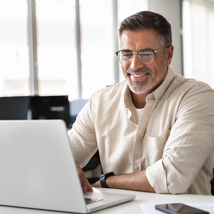 man smiling while looking at laptop