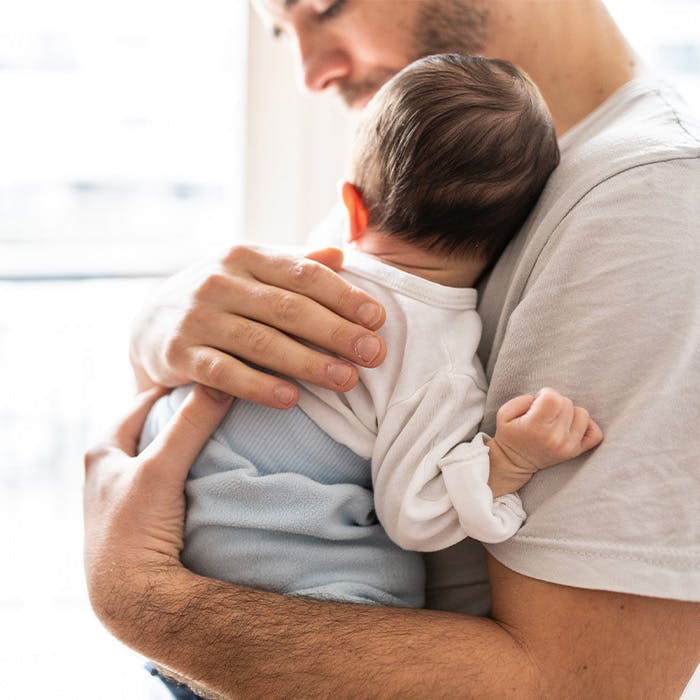 man holding baby on his chest